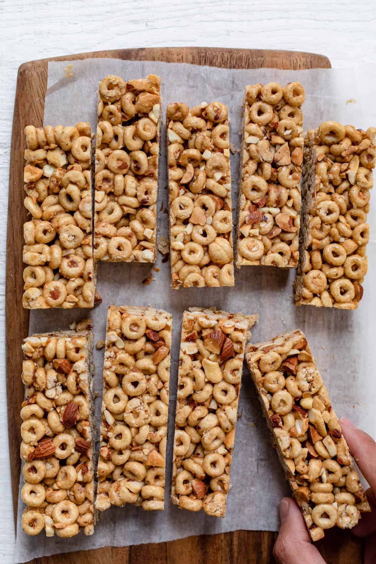 Honey nut cereal bars cut up on a board with parchment paper under