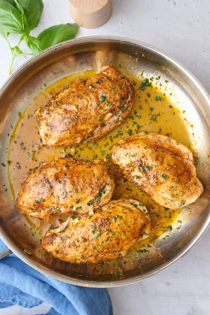 Stuffed chicken in the skillet garnished with chopped parsley.