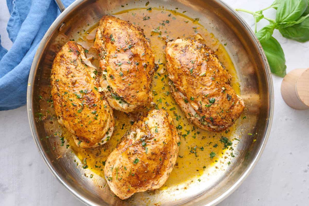 Stuffed chicken in the skillet garnished with chopped parsley.