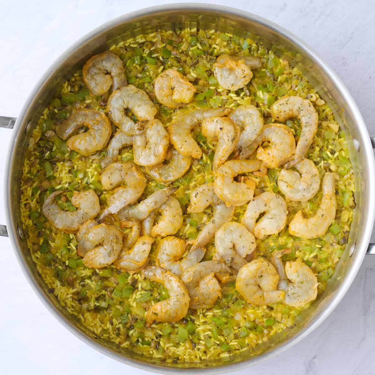 Shrimp added on top in an even layer before cooking.