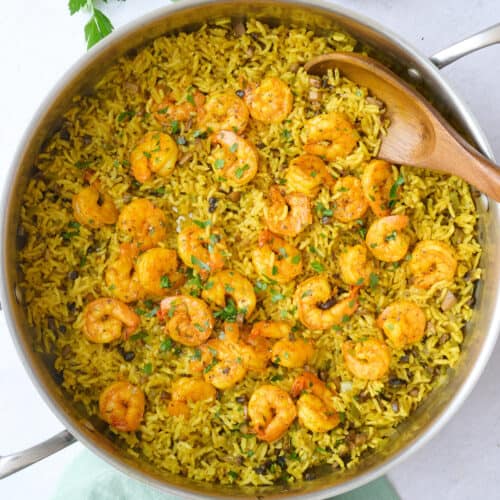Shrimp and rice in the pot after fluffing rice, garnished with chopped parsley.