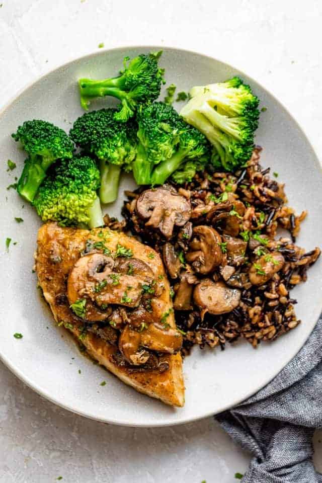 Plate of sauteed chicken with mushrooms, wild rice and broccoli