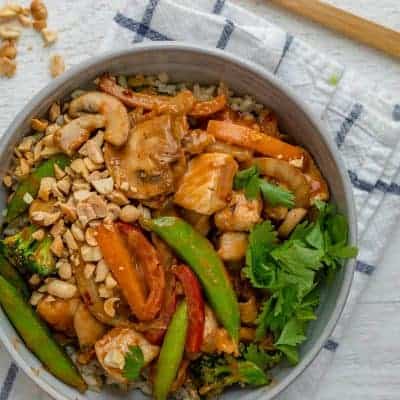 Thai peanut chicken stir fry serve in a bowl with brown rice