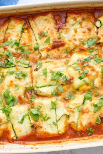 Zucchini ravioli in the baking dish garnished with basil.