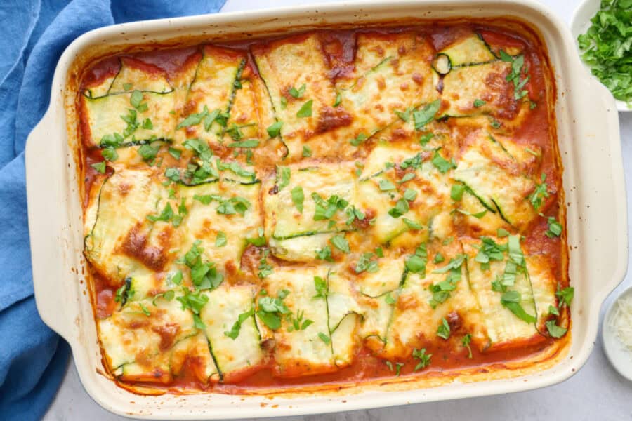 Zucchini ravioli in the baking dish garnished with basil.