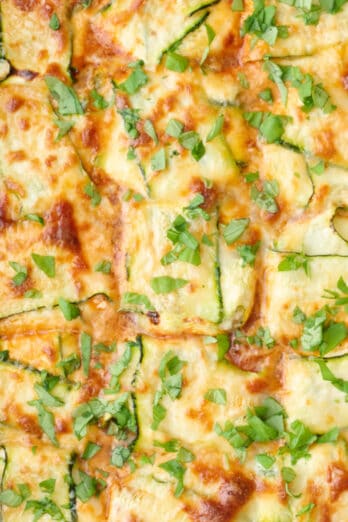 Zucchini ravioli in the baking dish garnished with basil.