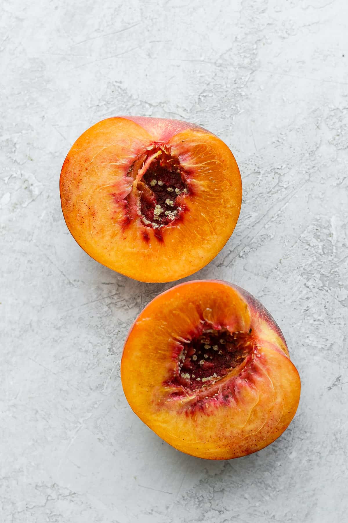 Two peach halves on white background