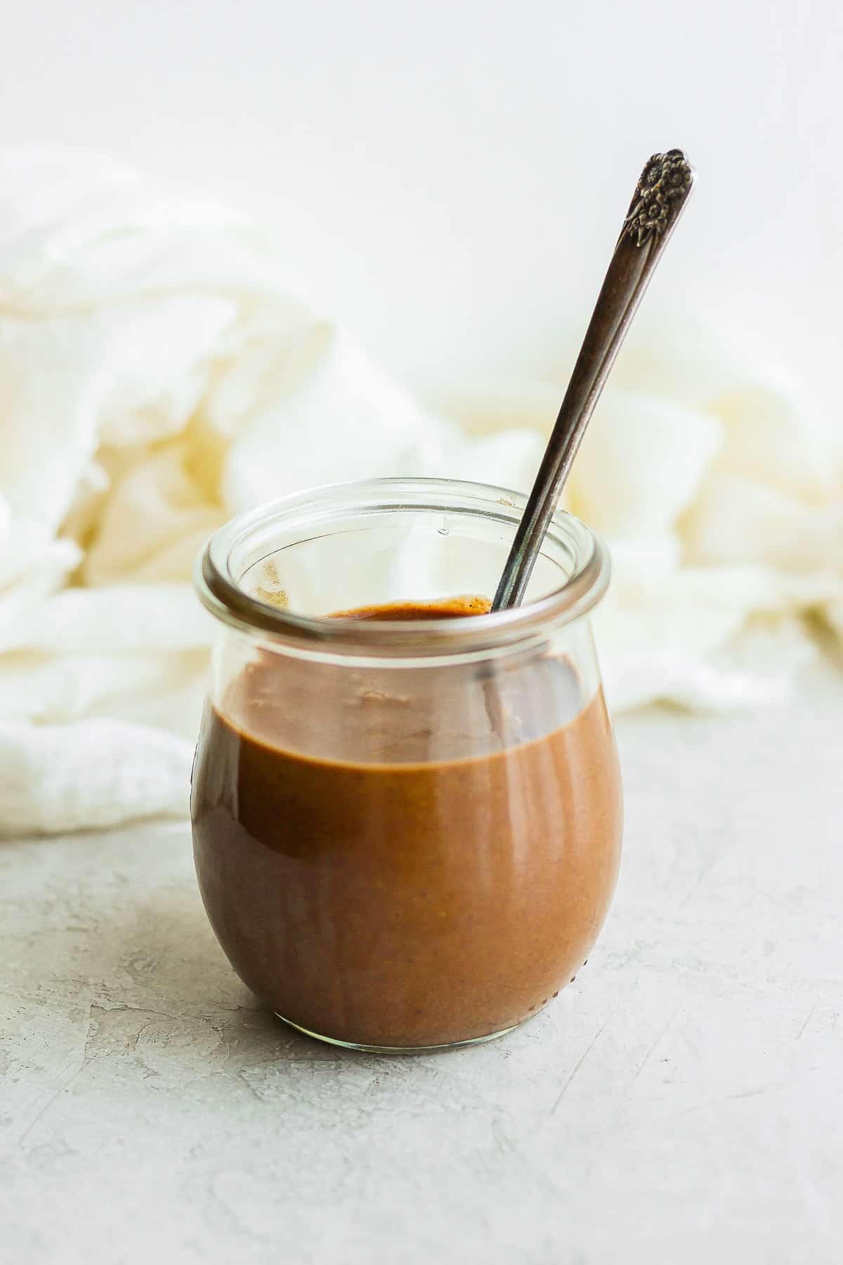 Homemade Nutella in glass jar with spoon insdie