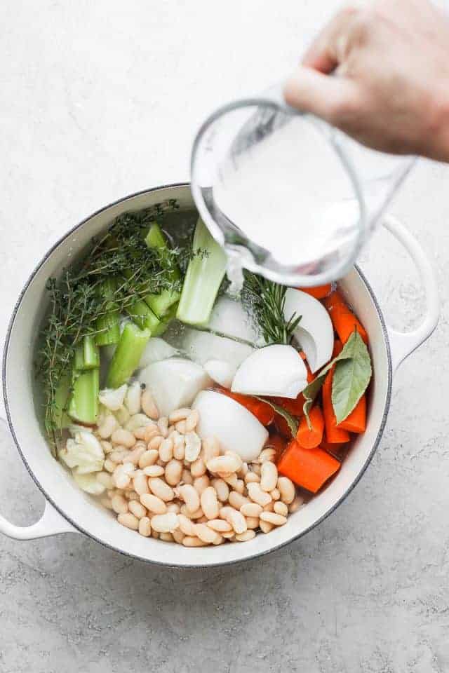 Dutch oven and pouring water on top of vegetables to make the stock