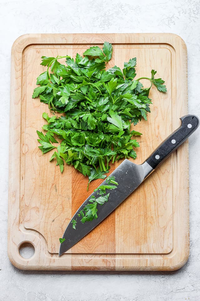 Cutting board with parsley and large chef's knife