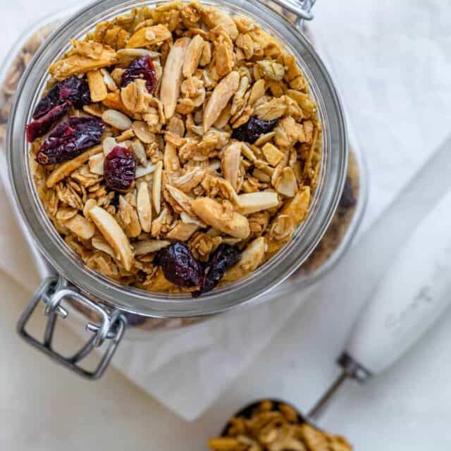 Homemade almond cranberry granola in a large glass jar