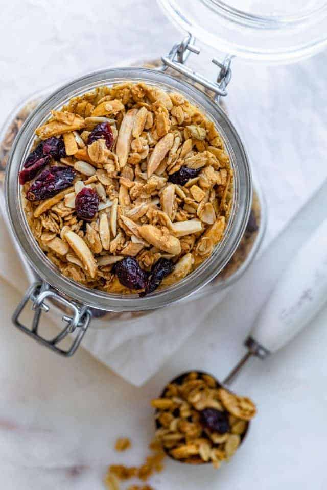 Homemade almond cranberry granola in a large glass jar