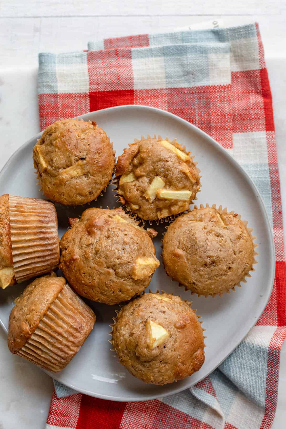 Apple cinnamon muffins on a plate with a red linen underneath