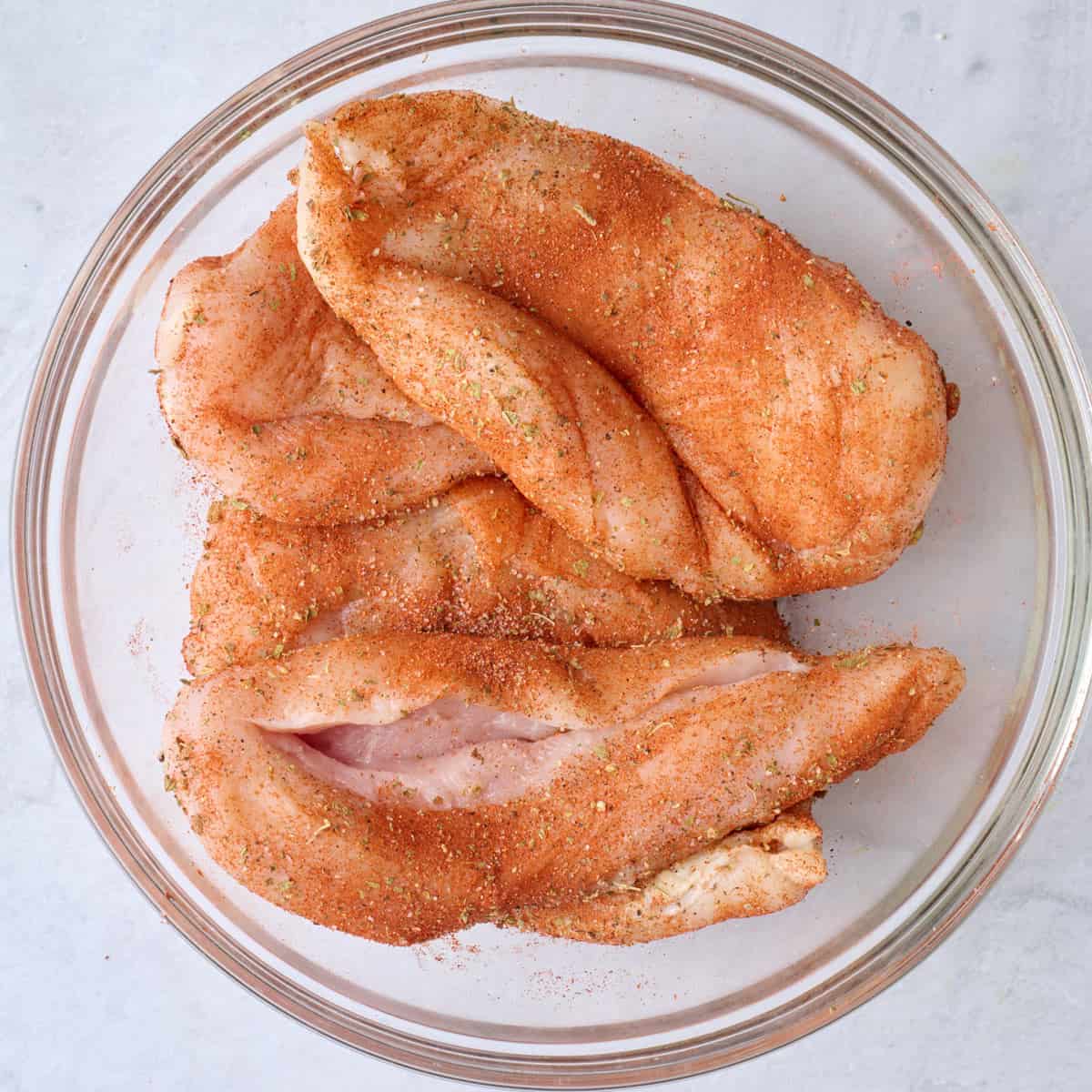 A bowl of seasoned chicken breasts.