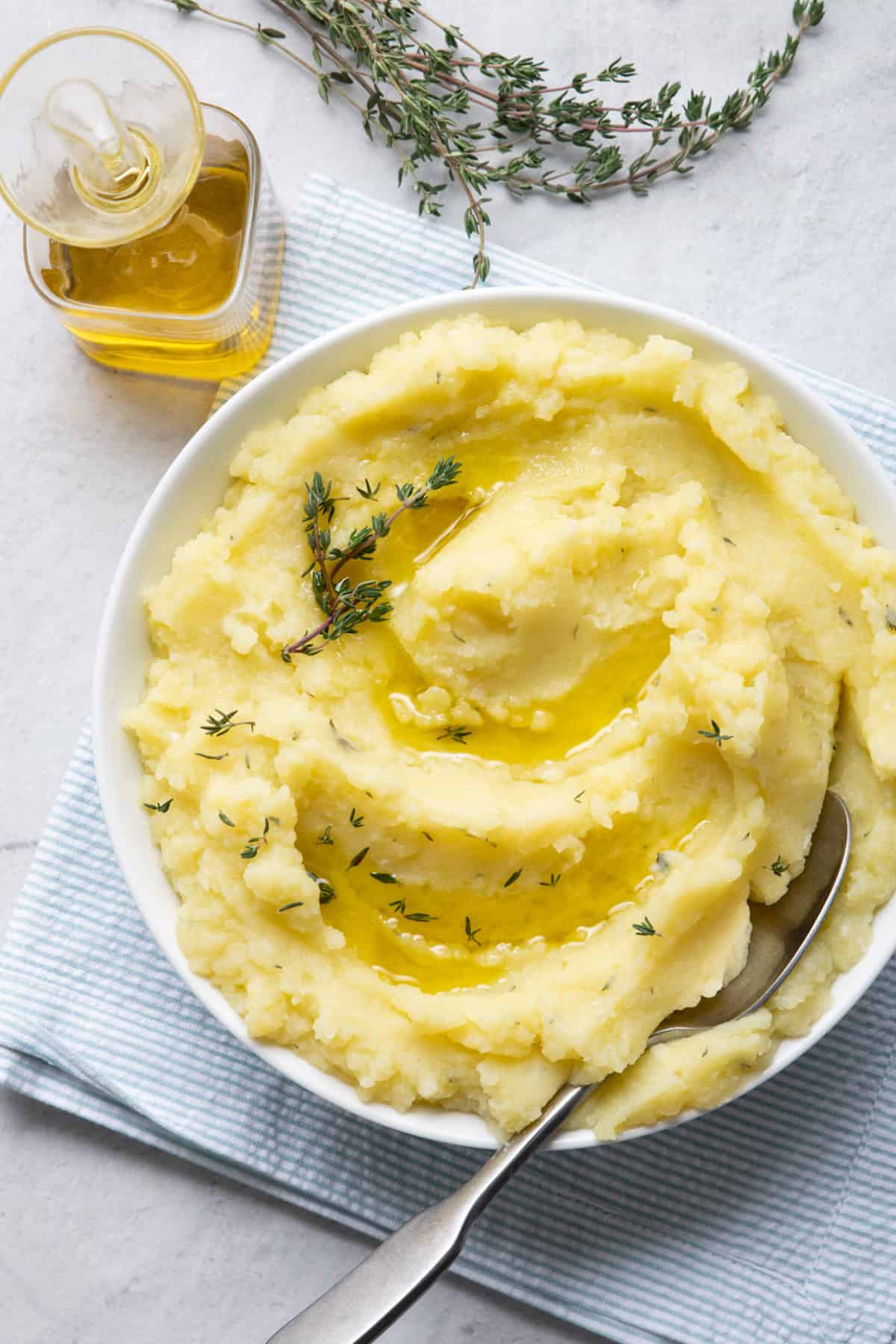 Mashed potatoes with olive oil in a large bowl with a spoon