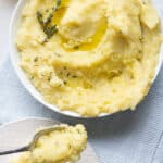Olive oil mashed potatoes in a large bowl with olive oil on top