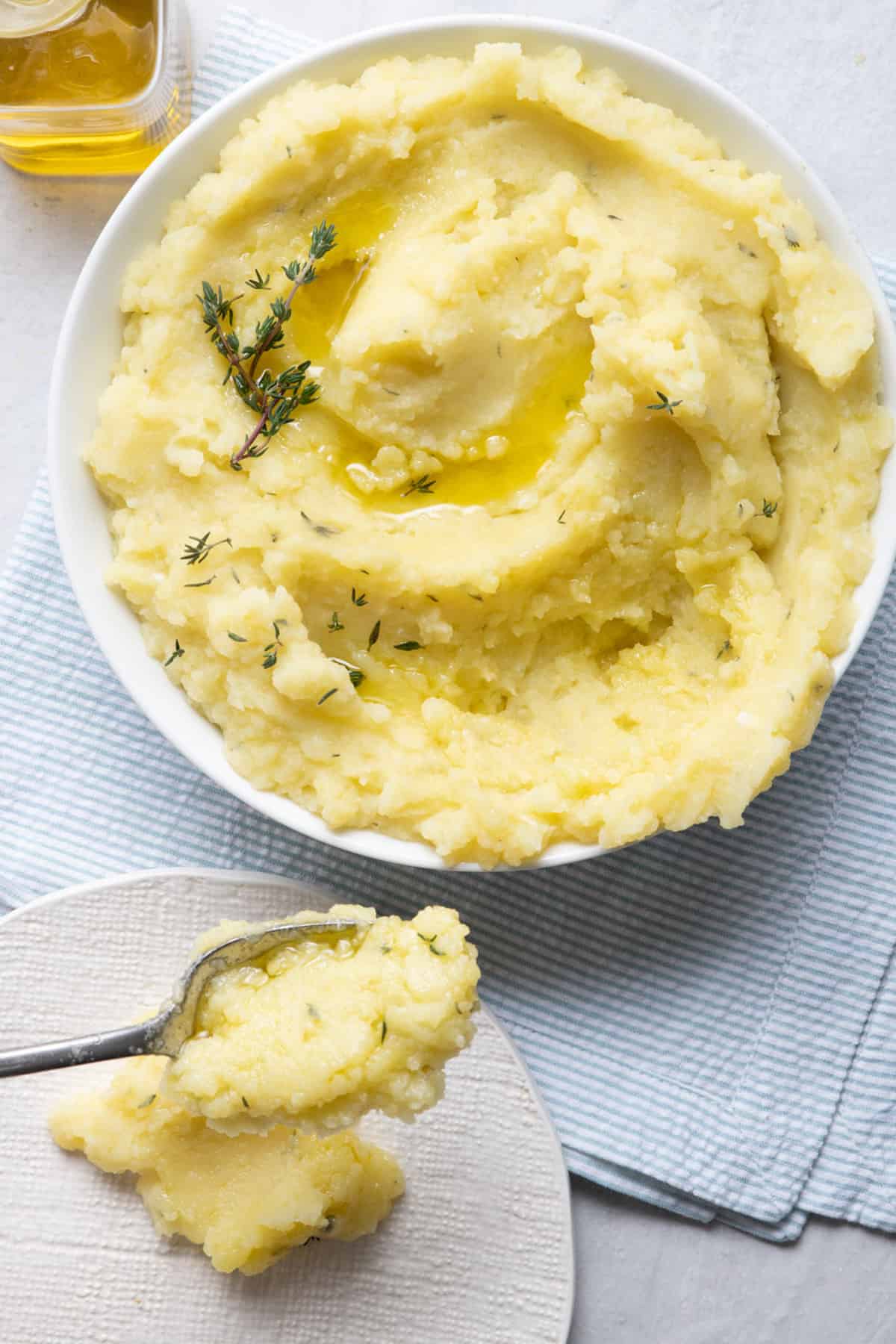 Olive oil mashed potatoes in a large bowl with olive oil on top