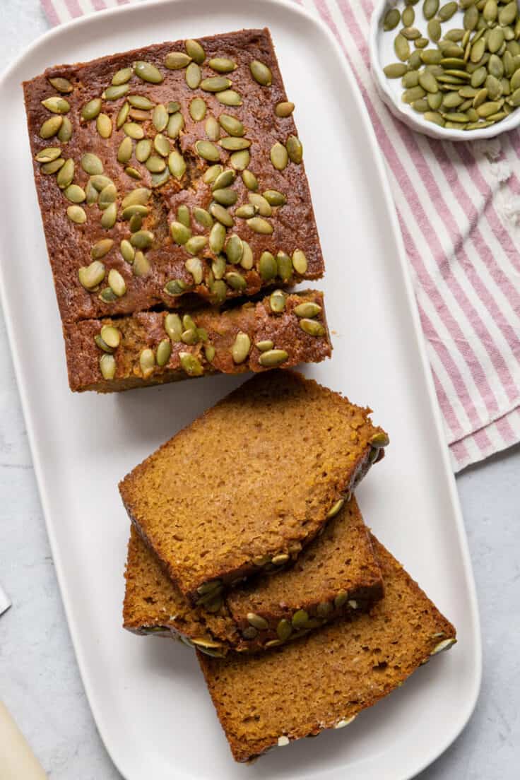 Starbucks Pumpkin bread topped with pumpkin seeds with some of the bread sliced
