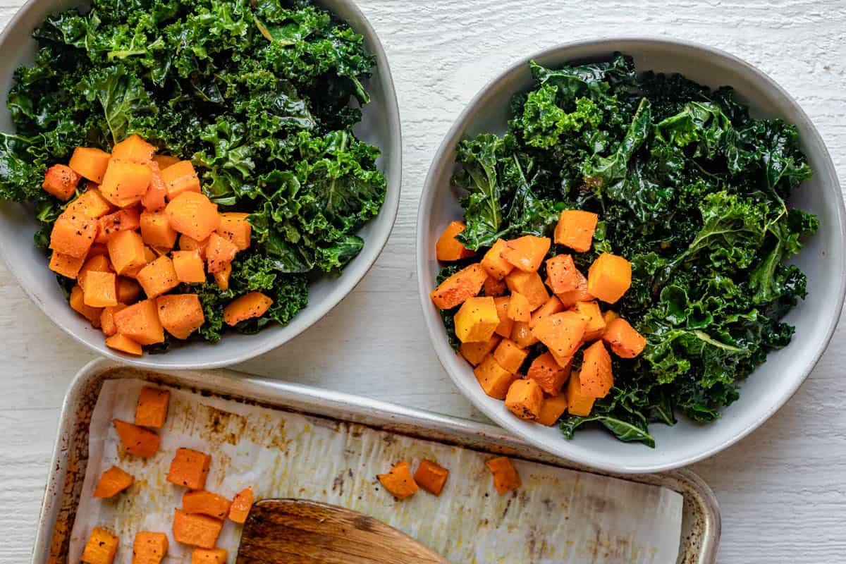 Showing how to assemble the grain bowl starting with kale and butternut squash in tow bowls