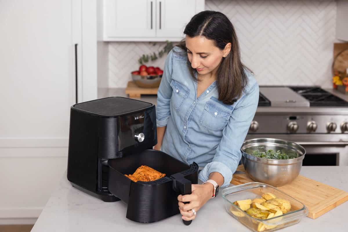 Yumna in kitchen with air frying and salmon in air fryer