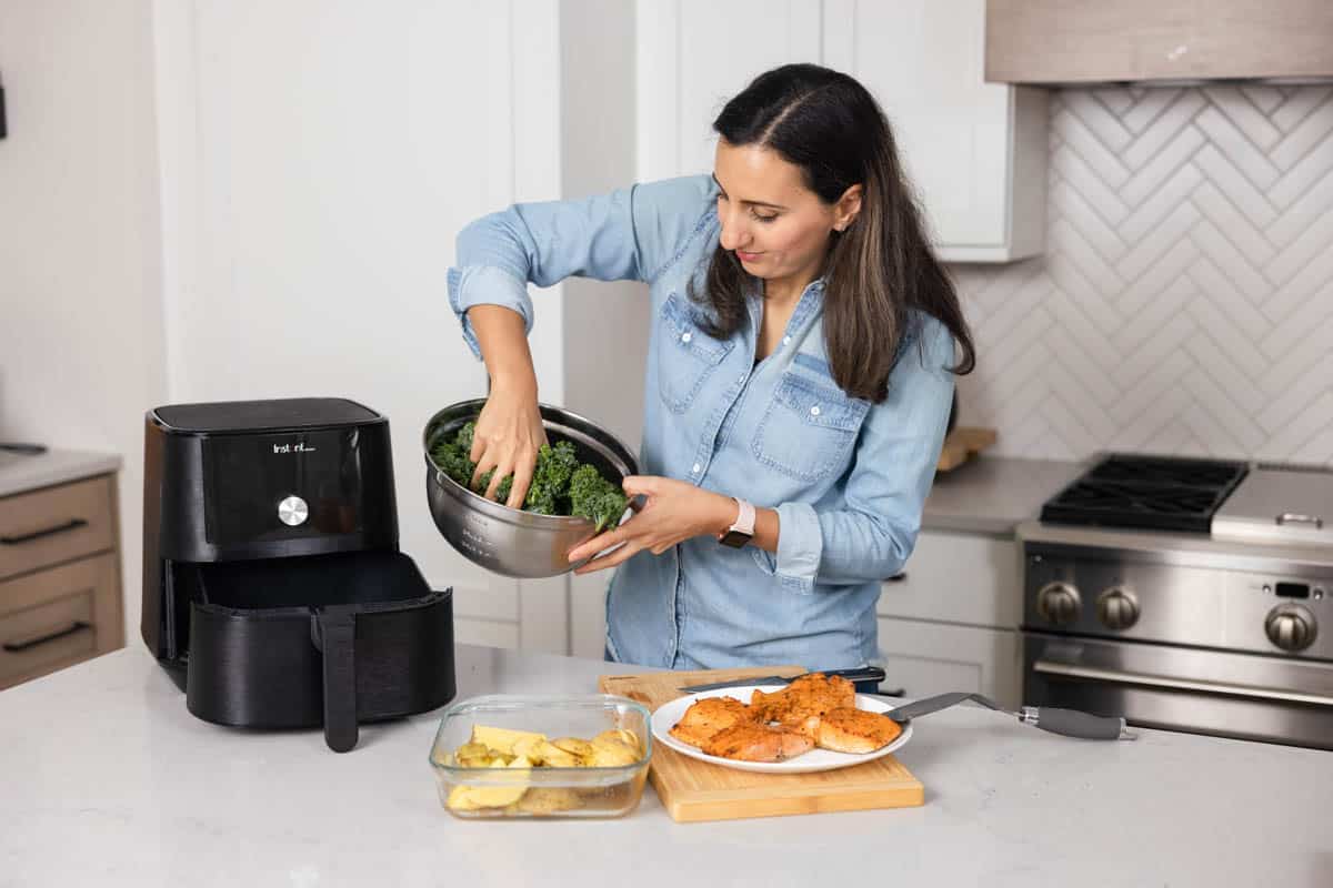 Yumna massaging kale in bowl before putting it in air fryer