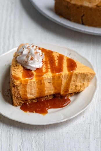 Slice of no bake pumpkin cheese with caramel on top and whipped cream
