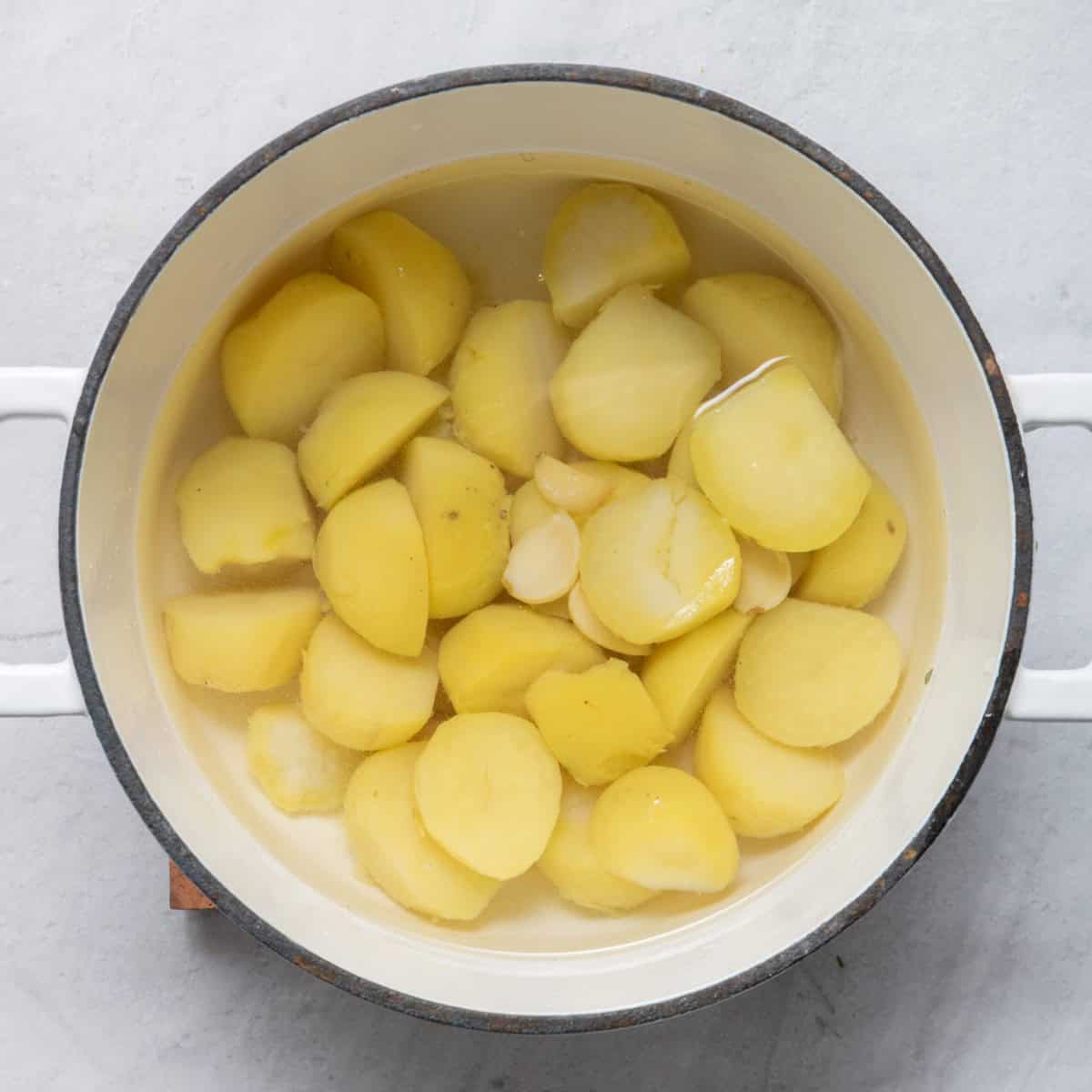 Potatoes, garlic and salt in pot of water.