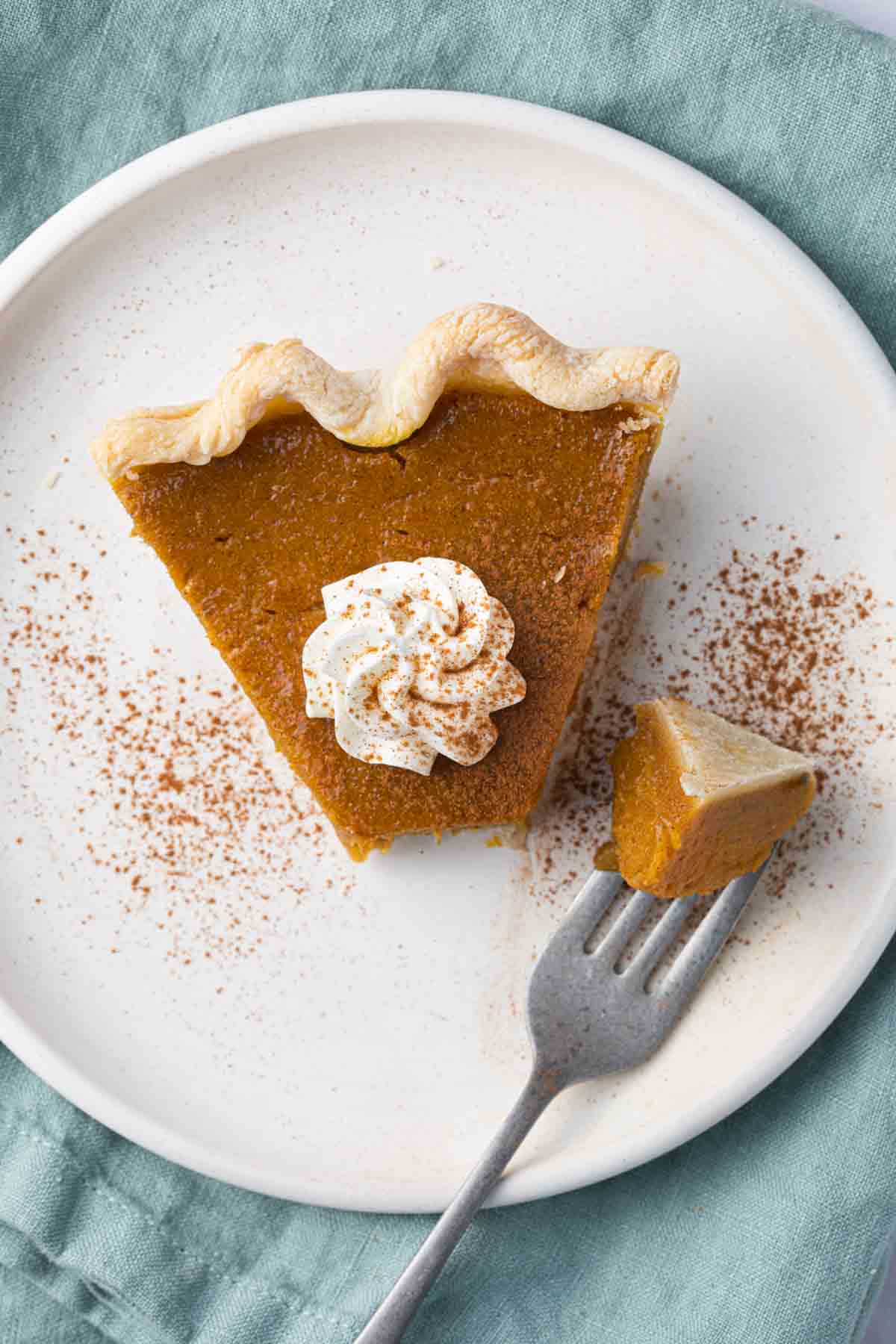 Plate of pumpkin pie with bite taken out