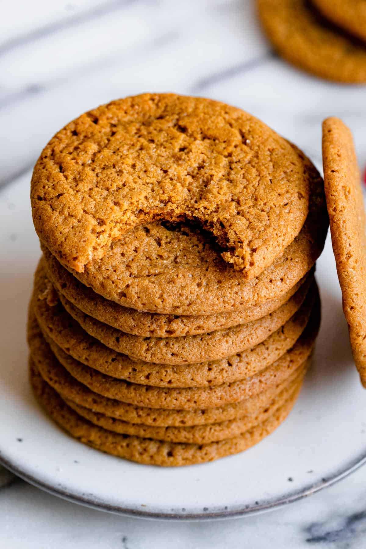 Close up shot of cookies made with cardamom spice with bite taken out of top cookie