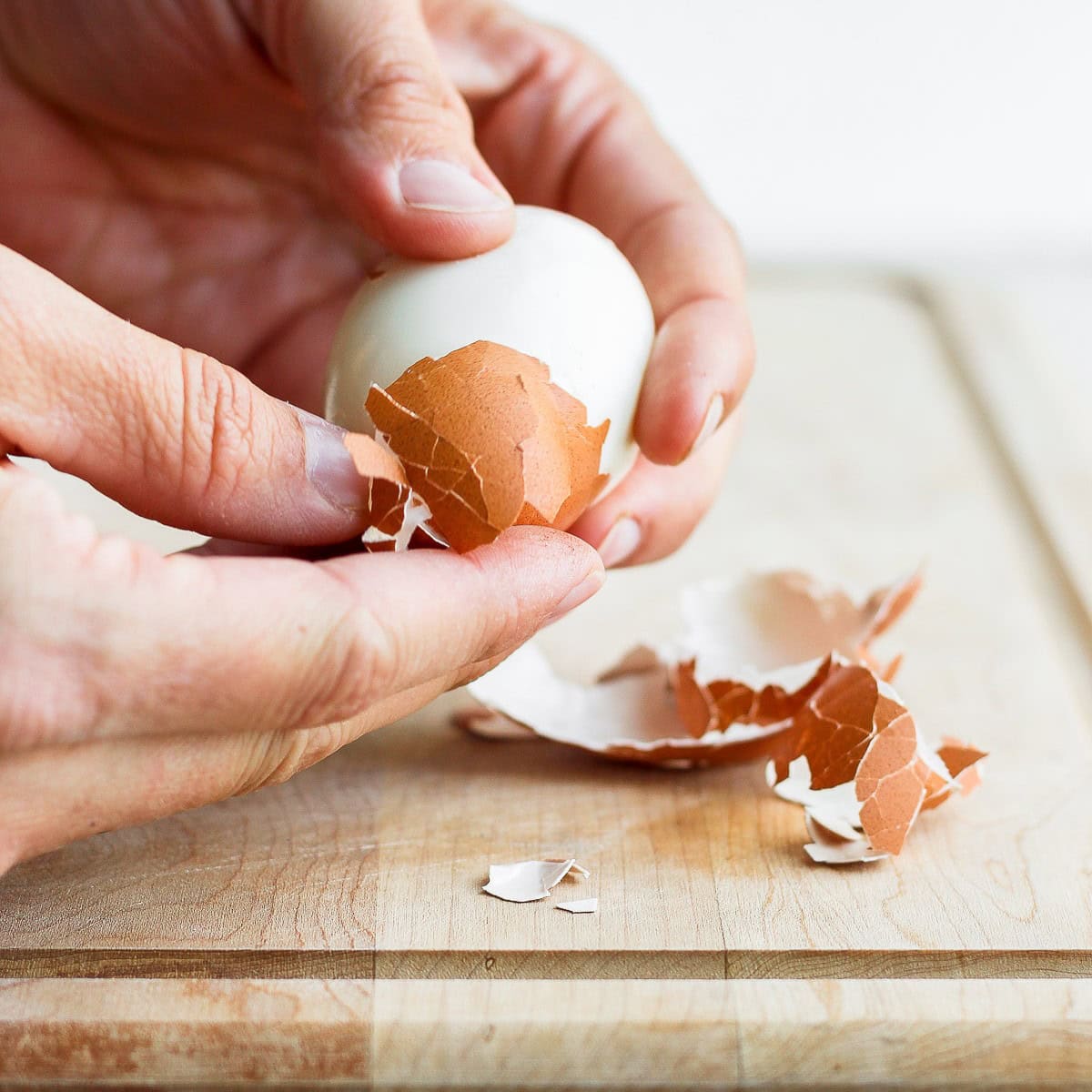 Peeling egg shell from egg.