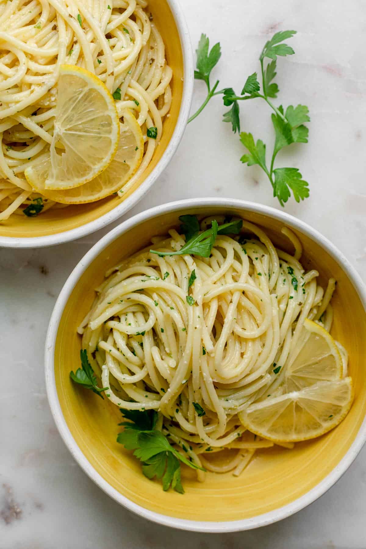 Two bowls of the lemon pasta served with fresh parsley