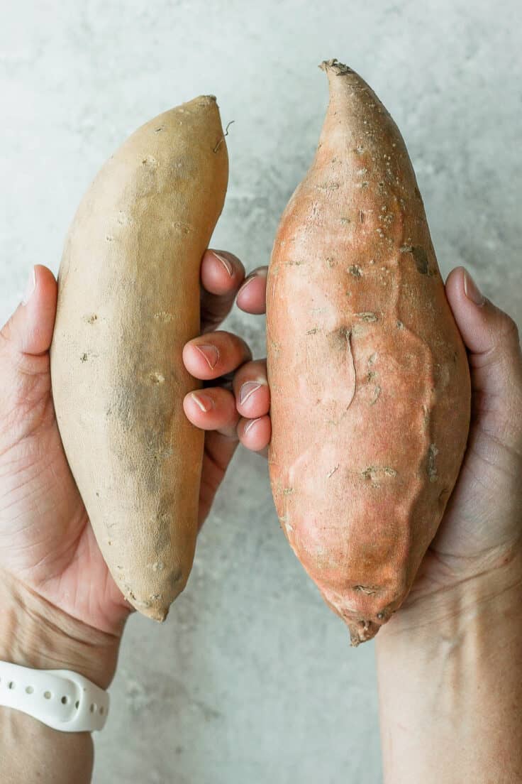 2 hands holding yam and sweet potato