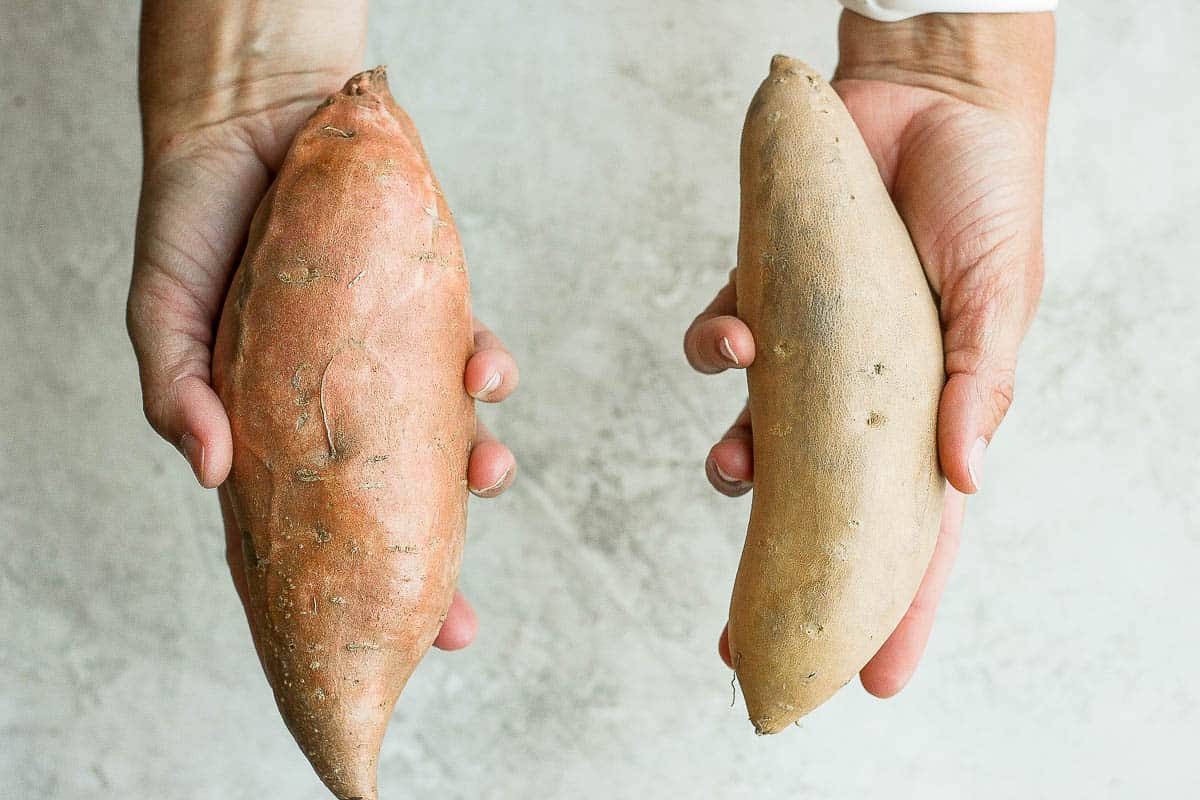 2 hands holding yam and sweet potato