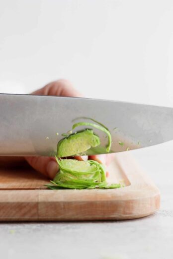 Chef's knife cutting a brussel sprout