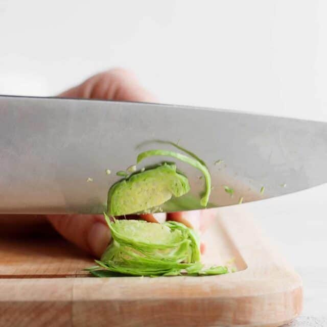 Chef's knife cutting a brussel sprout