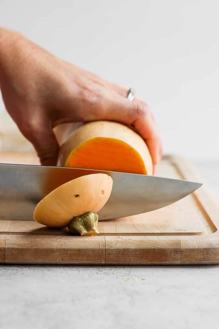 Butternut squash on cutting board getting cut