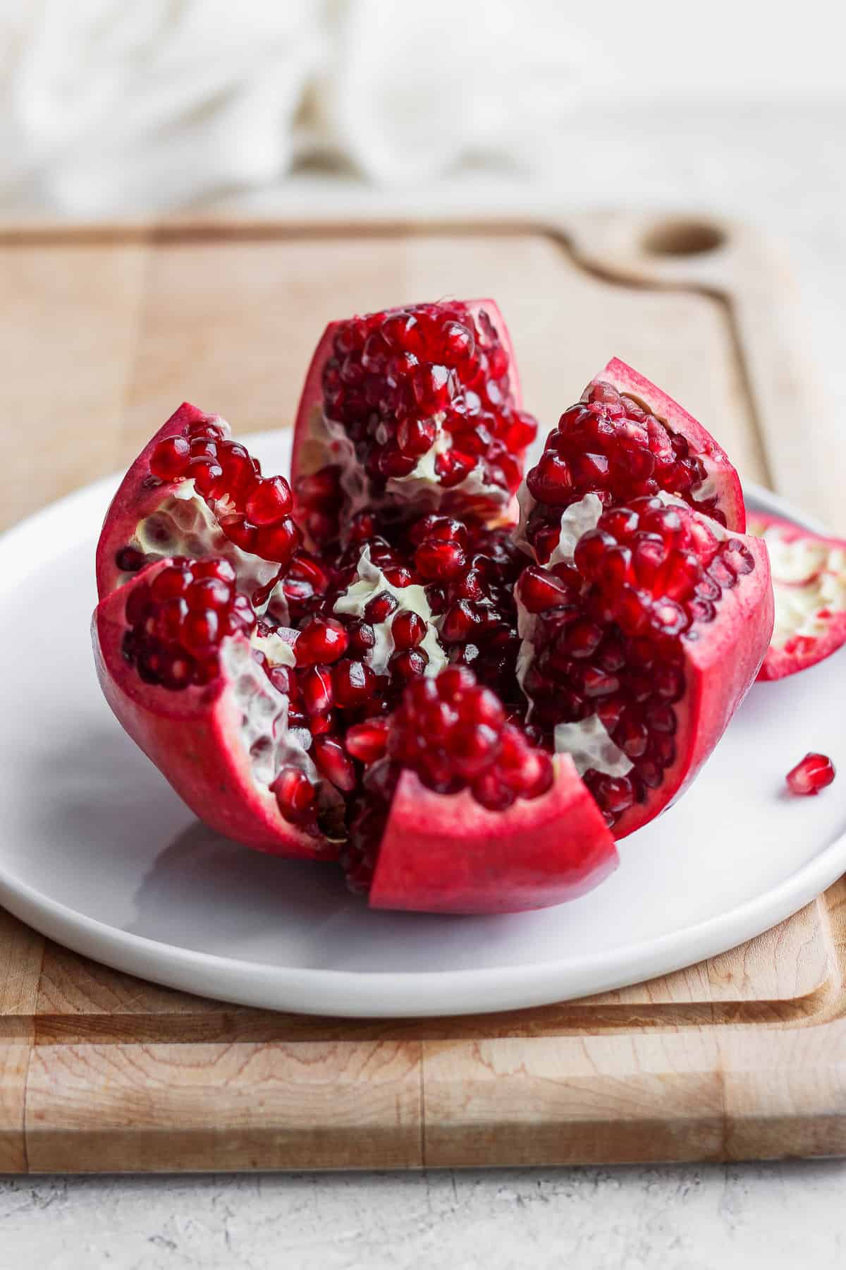 Pomegranate cut into segments on white dish