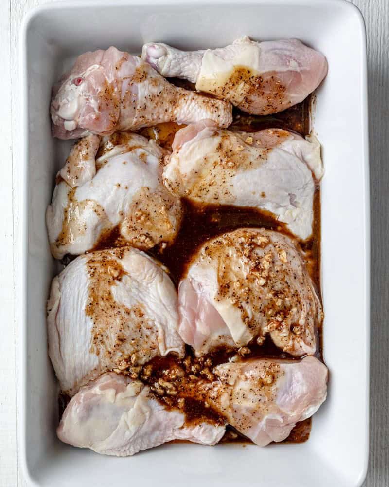 Chicken in baking dish with sauce drizzled.