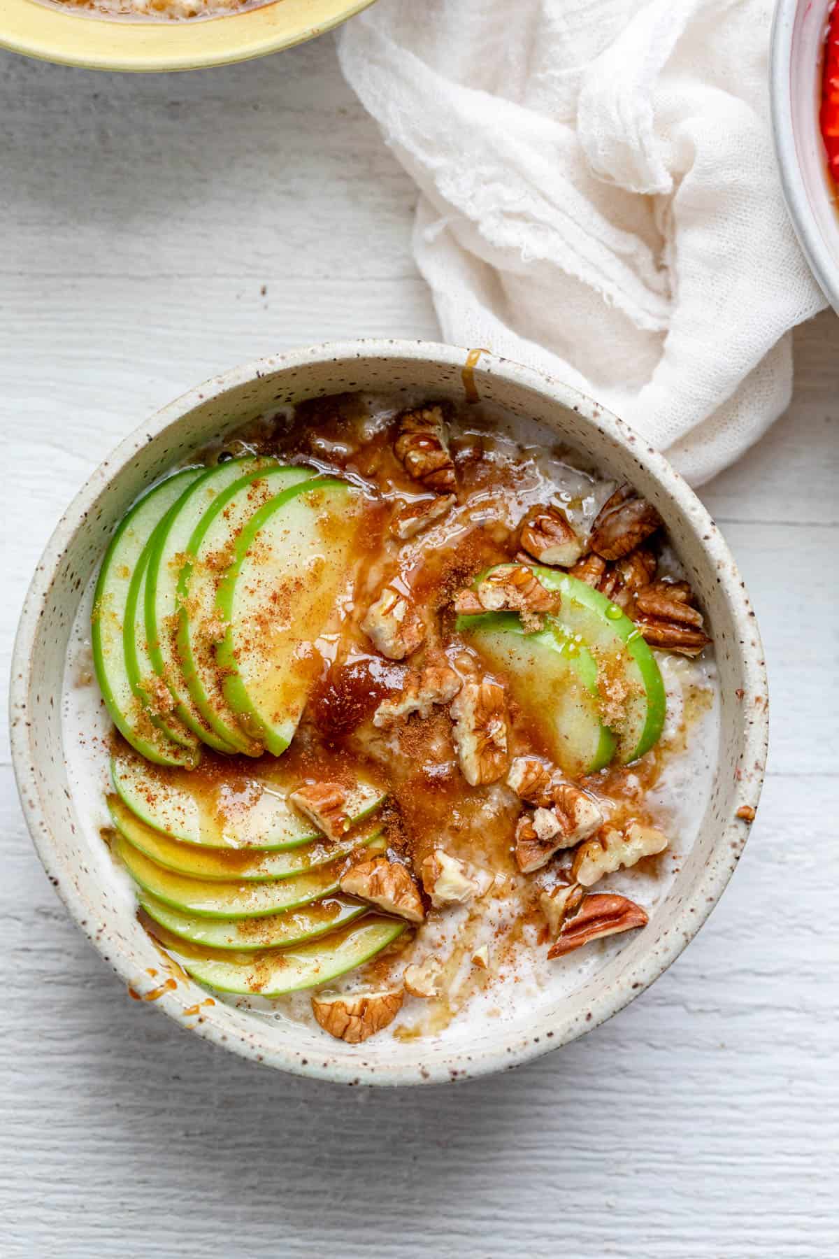 Sliced green apples, caramel sauce and pecans over oatmeal