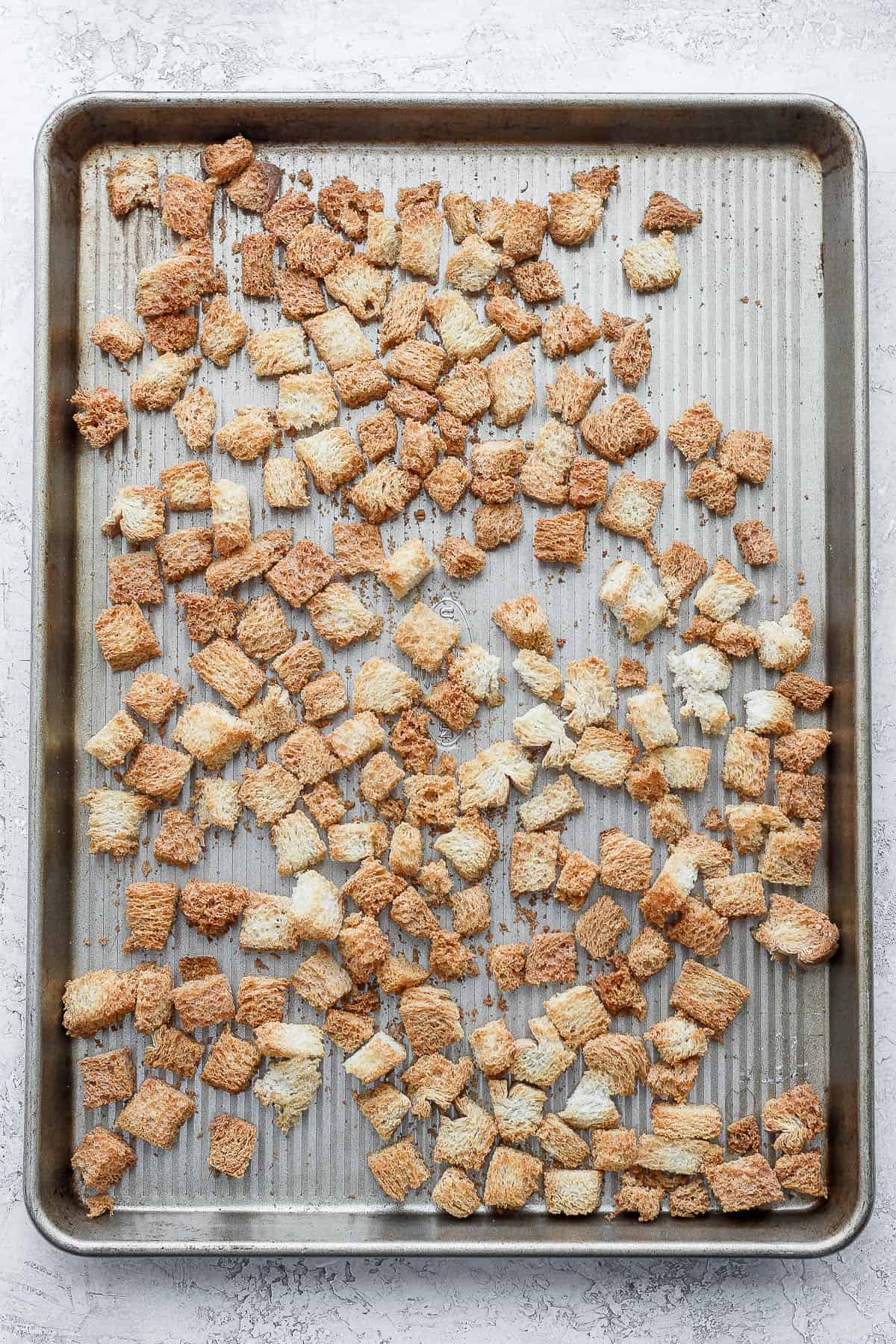 Toasted cubed bread on large baking dish