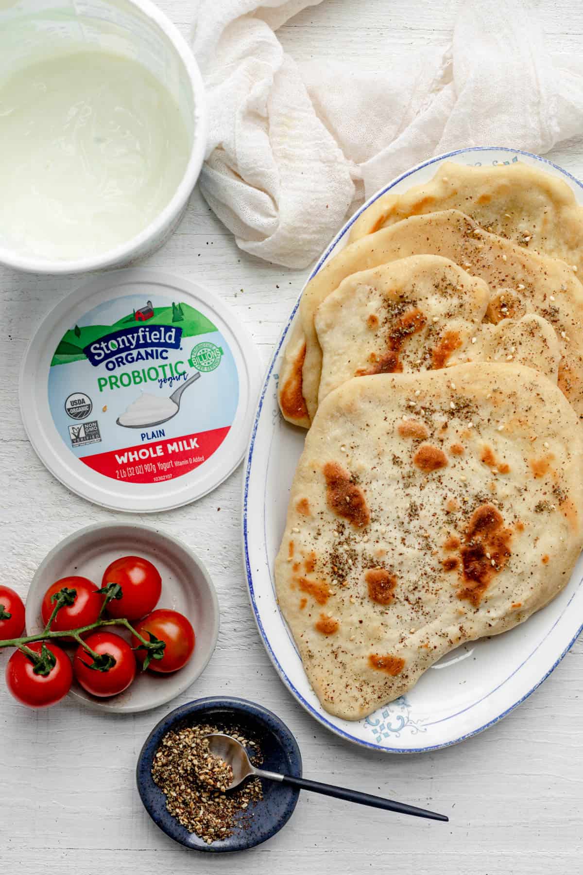 Serving plate with flatbread and open container of Stonyfield yogurt next to it