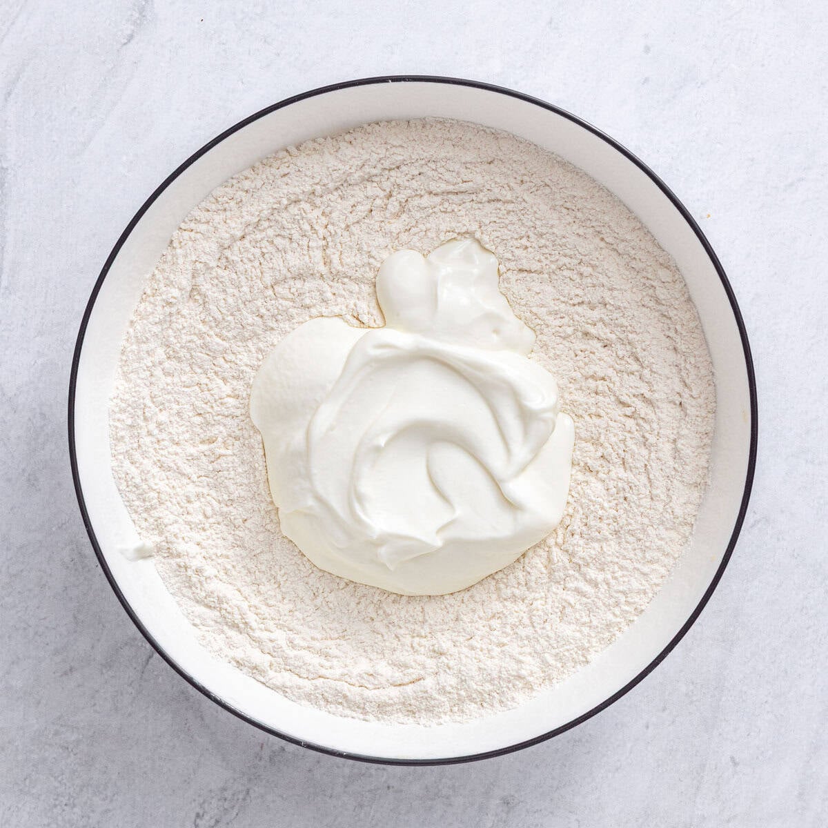 Dry ingredients in a large bowl after whisking together with yogurt added.