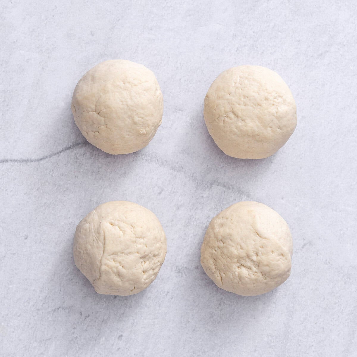 Dough divided into 4 equal parts after resting.