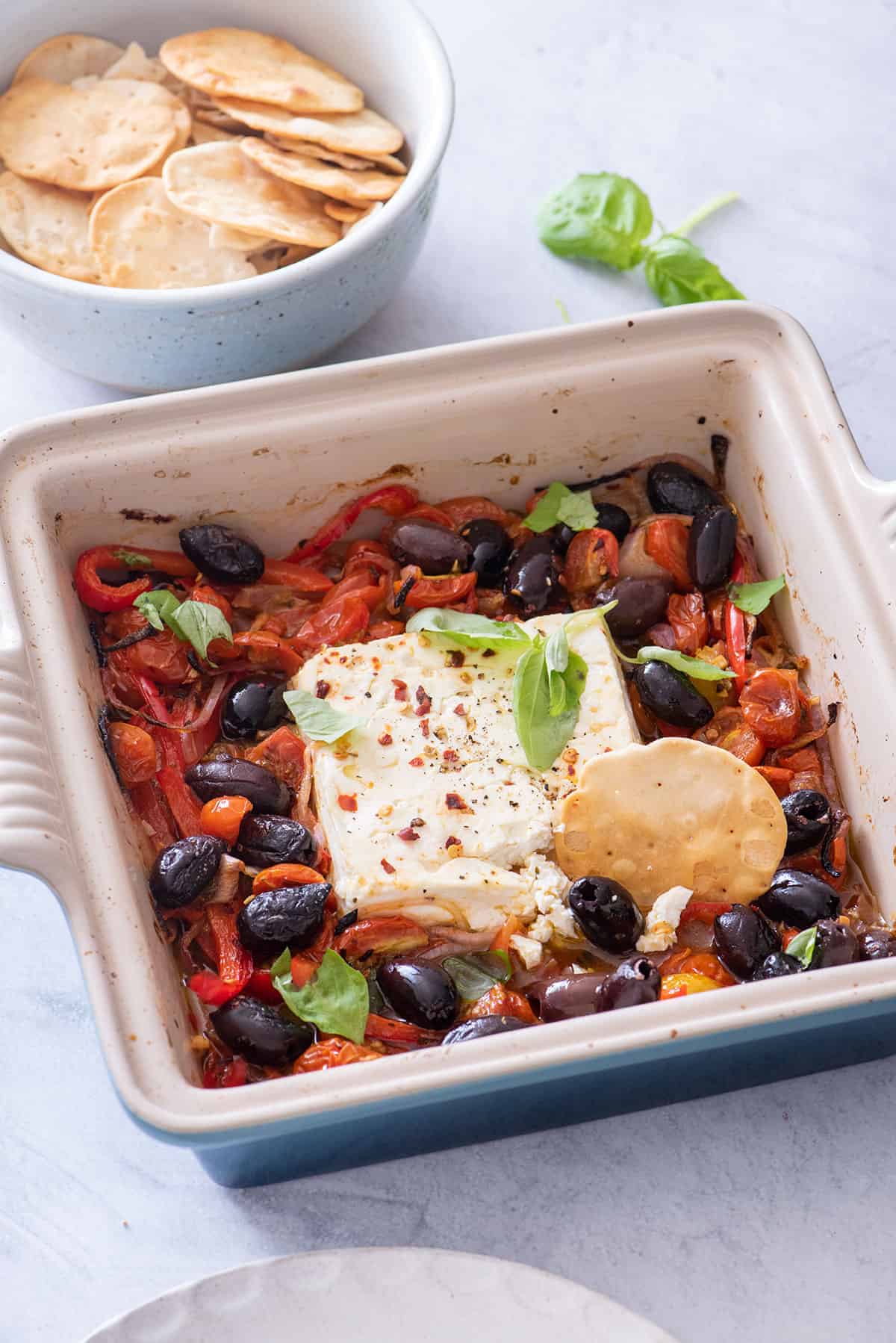 Close up shot of baked feta dip with cracker for dipping