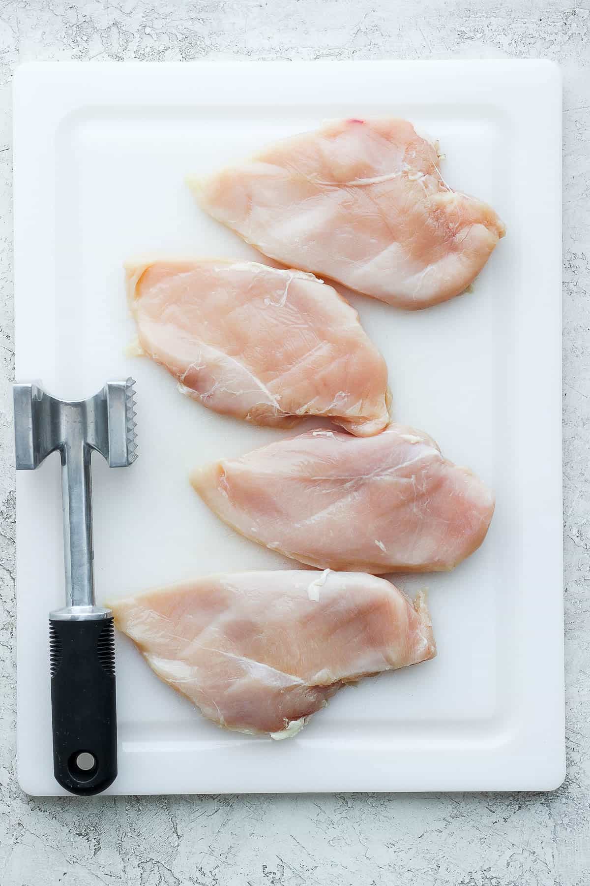 preparing chicken by using a mallet to pound it