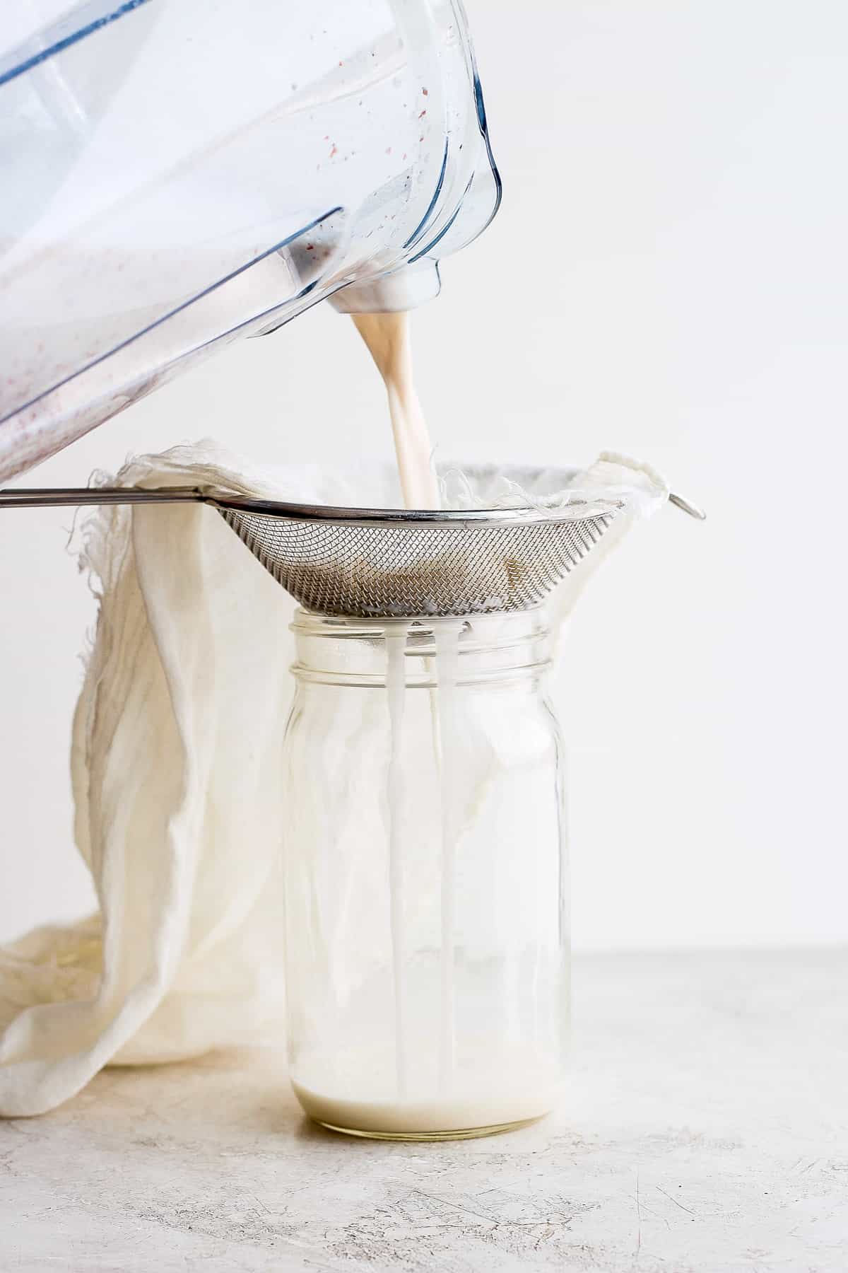 Straining almond milk in a cheese cloth