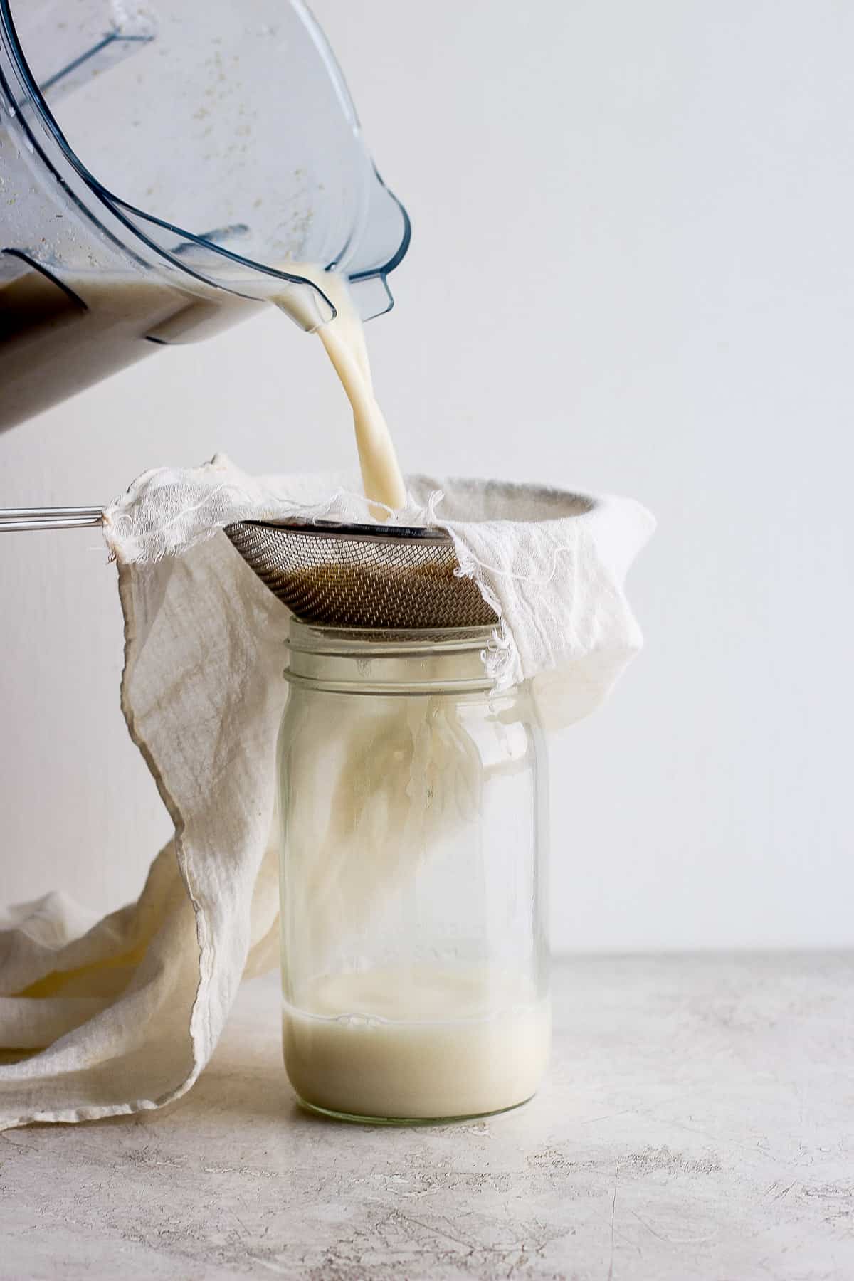 Straining the oat milk with a cheese cloth
