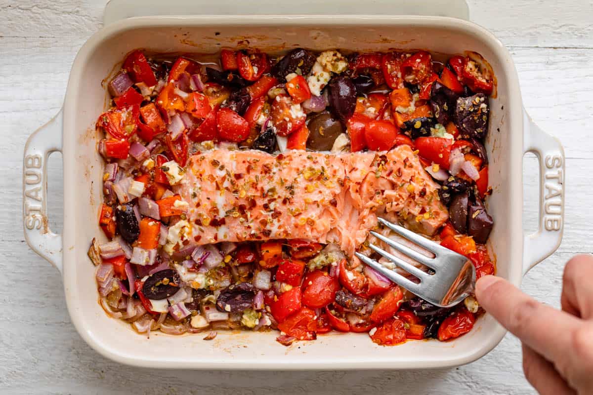 Fork on top of salmon flaking it off to show the texture