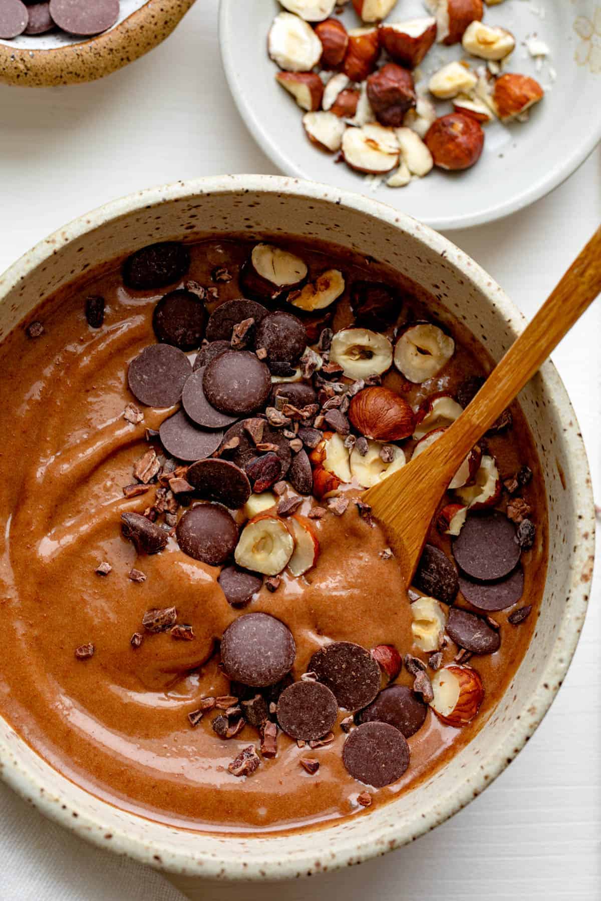 Close up of chocolate hazelnut smoothie bowl with wooden spoon inside
