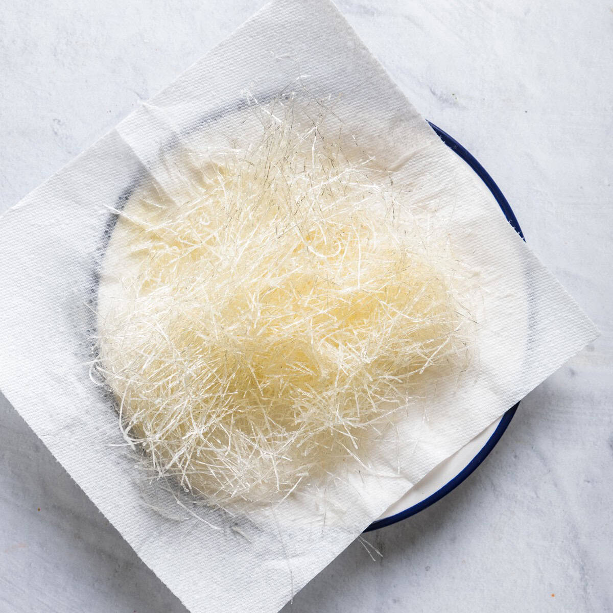 Toasted vermicelli noodles on a paper towel sitting on a plate.